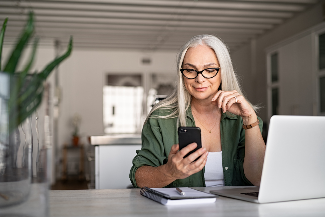 woman wearing glasses looking at her phone 